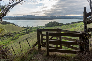 Fototapeta na wymiar Elevated view of Puriri Bay in Whangaruru Harbour, Northland, New Zealand. A fence and gate in the foreground.