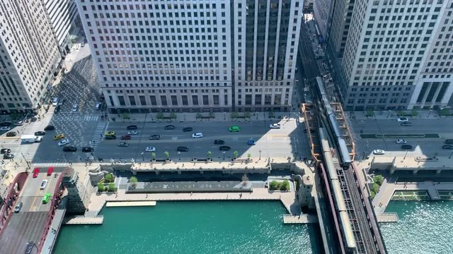 Two Chicago el trains crossing the Chicago River over the Wells Street bridge on glittering spring morning.