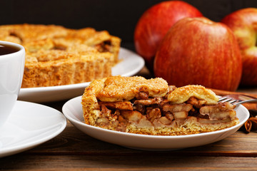 Closeup piece of homemade apple pie with cinnamon and cup of tea