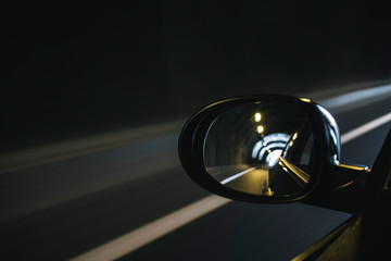 Oval mirror car reflecting highway driving inside a tunnel