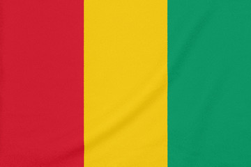 Flag of Guinea on textured fabric. Patriotic symbol