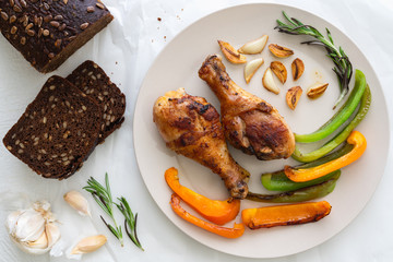 Fried Chicken, Roasted Paprika, Roasted Garlic and Rosemary on a Plate Top View Close Up on White Background