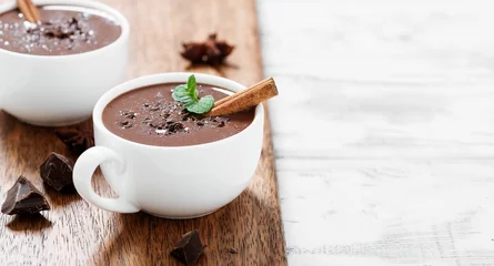 Poster Hot chocolate drinks and chocolate pieces in white cup. © Nelea Reazanteva