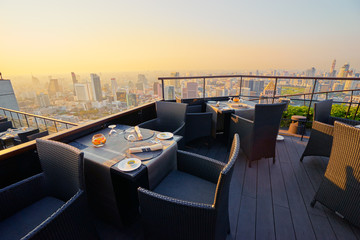 Fototapeta na wymiar Table setting on roof top restaurant with megapolis view, Bangkok Thailand.