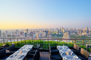 Table setting on roof top restaurant with megapolis view, Bangkok Thailand.