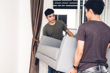 Two man carrying a sofa and moving into their new home.House moving and real estate concept