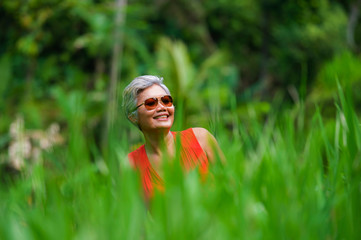 natural lifestyle portrait of beautiful and happy middle aged 40s or 50s Asian woman with grey hair...