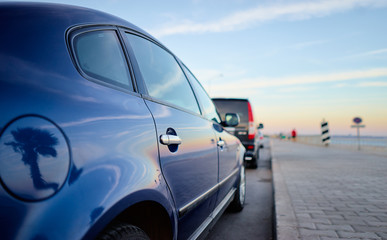 Obraz na płótnie Canvas Sky reflecting on surface of blue car. Street parking.