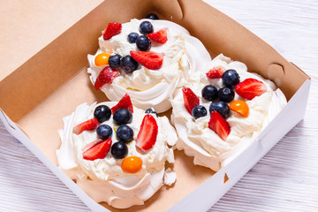 Set of white cakes, Meringue with fruits and berries in carton box