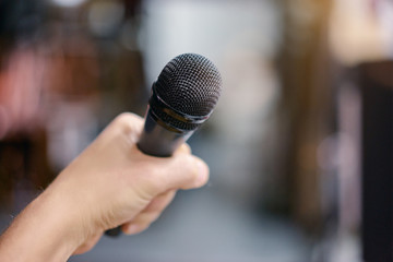 Close up male hand holding microphone.