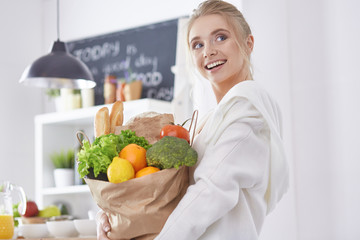 Young woman holding grocery shopping bag with vegetables Standi