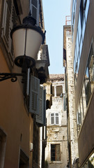 Stone houses with green windows in narrow street of old town, beautiful architecture, sunny day, Split, Dalmatia, Croatia