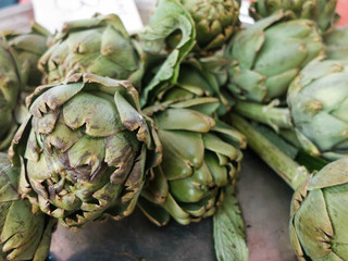 Obraz premium Green artichokes at the country market counter