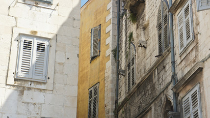 Stone houses with windows in the street of old town, beautiful architecture, sunny day, Split, Dalmatia, Croatia
