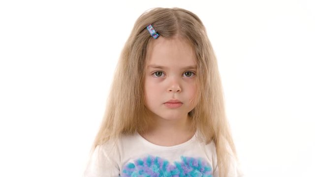 Video portrait of a sad child girl isolated on white background. Childhood concept. Studio shot of child emotions in 4K definition.