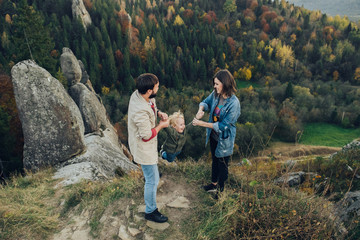 Young family with little son spending time together outside.