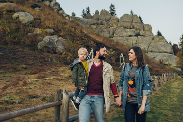 Young family with little son spending time together outside.
