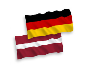 National Vector Fabric Wave Flags Of Germany And Latvia Isolated On White Background. 1 to 2 proportion.