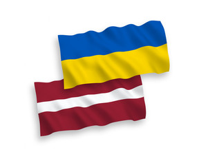 National vector fabric wave flags of Latvia and Ukraine isolated on white background. 1 to 2 proportion.