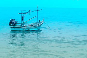 Fototapeta na wymiar Fishing boat near shore in blue sea and blue sky meet. Thailand holiday summer vacation concept idea.