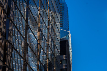 Dark Glass Multi Tiered High Rise Structure Against Blue Sky