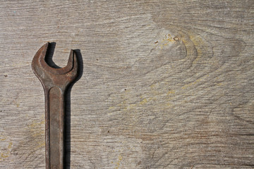 Old rusty wrench on wooden background