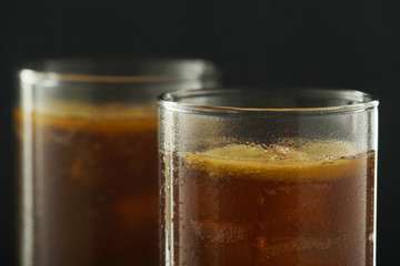 Glasses with cuba libre cocktail or cola with ice or cold tea with lemon