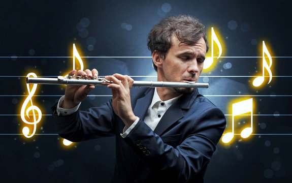 Young handsome flautist playing with music sheet background