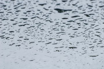 Water spray on a glass mirror with reflections.