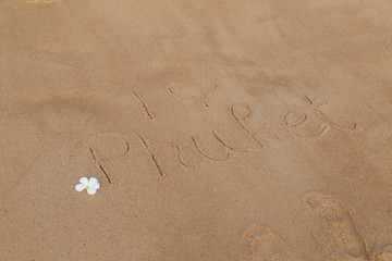 Schrift im Sand I love Thailand Phuket mit Blüte
