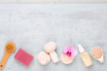 Sea salt, aromatherapy oil in bottles and orchid on vintage wooden background.