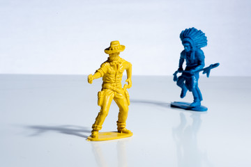 Blue indian and yellow cowboy plastic toy figures.