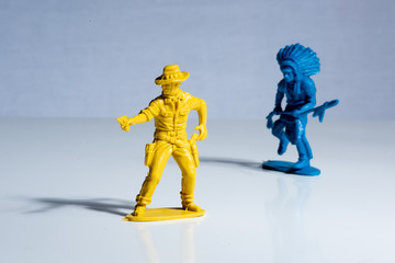 Blue indian and yellow cowboy plastic toy figures.