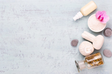 Sea salt, aromatherapy oil in bottles and chamomile on vintage wooden background.