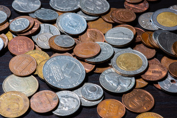 Different kinds of coins on a black table.