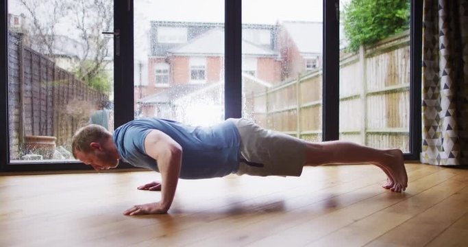 4K Caucasian man doing push ups, working out at home. Slow motion.