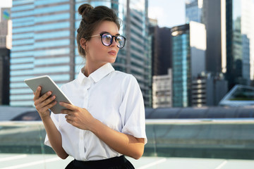 Woman wearing smart casual clothing  is using tablet pc