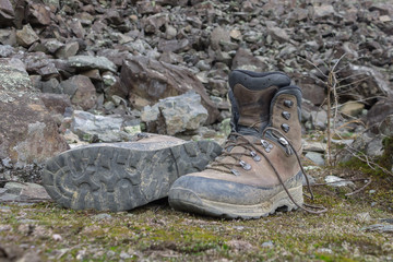 Dirty boots for hiking on stones in the forest after a hike