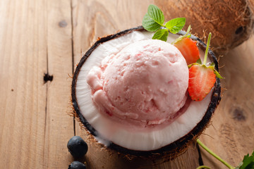 Strawberry ice cream in coconut on wooden  table.