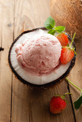 Strawberry ice cream in coconut on wooden  table.