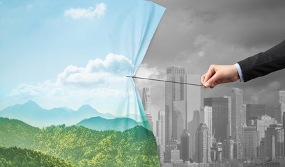 hand pulling green cityscape curtain to gray cityscape, environmental protection concept