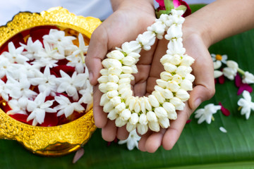 jasmine garland in child hand isolated on green background ,Thai moter's day concept ,Songkran...