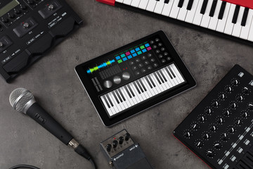 Piano synthesizer app on tablet and musical instrument concept
