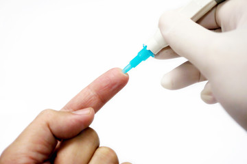 Hand of doctor in white medical glove holding needle pen stab on human forefinger to check glucose...