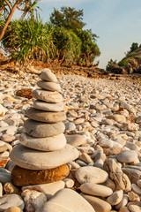 Cairn zen meditation, stones balance on stone beach, tropical trees and mountain blurred backgrounds. Lanta Island, Thailand.