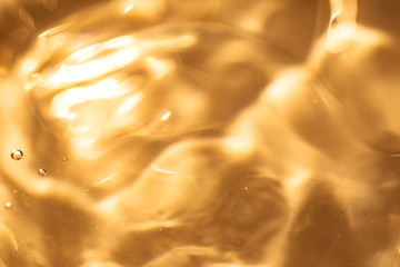 金色の液体・水・テクスチャ。美容や健康イメージ。
