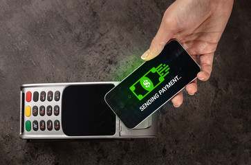 Hand paying with digital currency from smartphone
