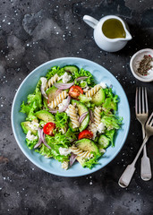 Mediterranean pasta avocado salad on a dark background, top view. Vegetarian diet food concept