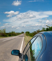 Blue skies reflecting on the car glass, car on the side of the road