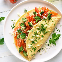 Fototapeta na wymiar Stuffed omelette with tomatoes, red bell pepper and broccoli